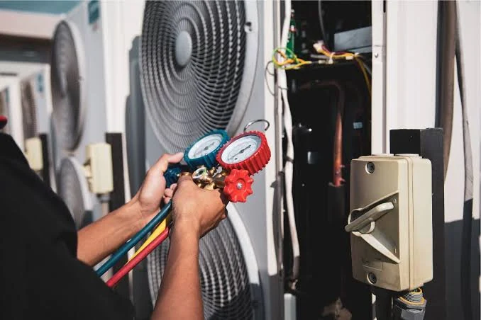 Refrigerant pressure gauges connected to an outdoor heating and cooling unit